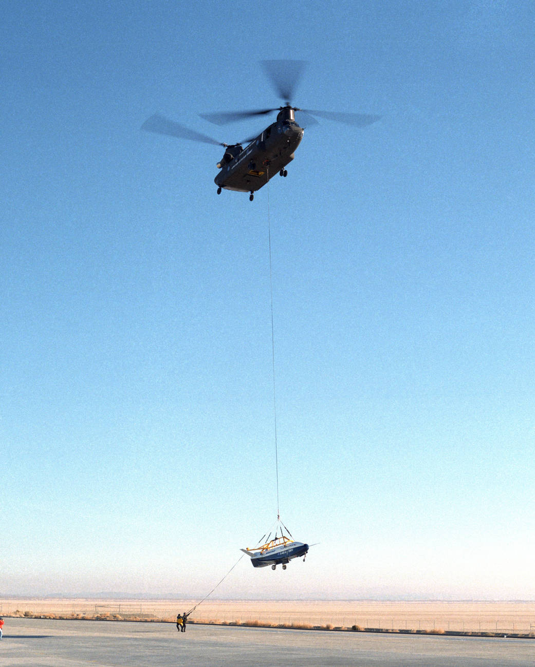 Ground crewmen help guide the X-40A as it is lowered to the ground.
