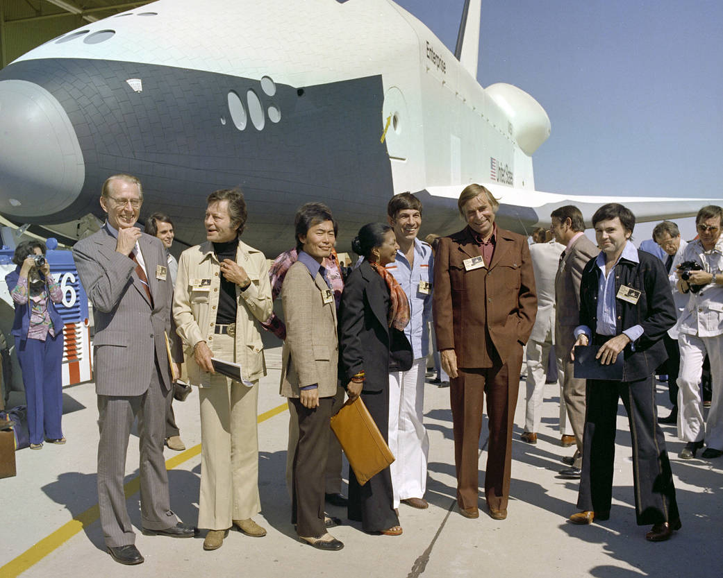 In this image, the then Dryden Flight Research Center (now Armstrong) hosted the Star Trek crew in 1976 for the rollout of Space Shuttle Enterprise posing with the cast is then NASA Administrator James Fletcher and show creator, Gene Roddenberry.