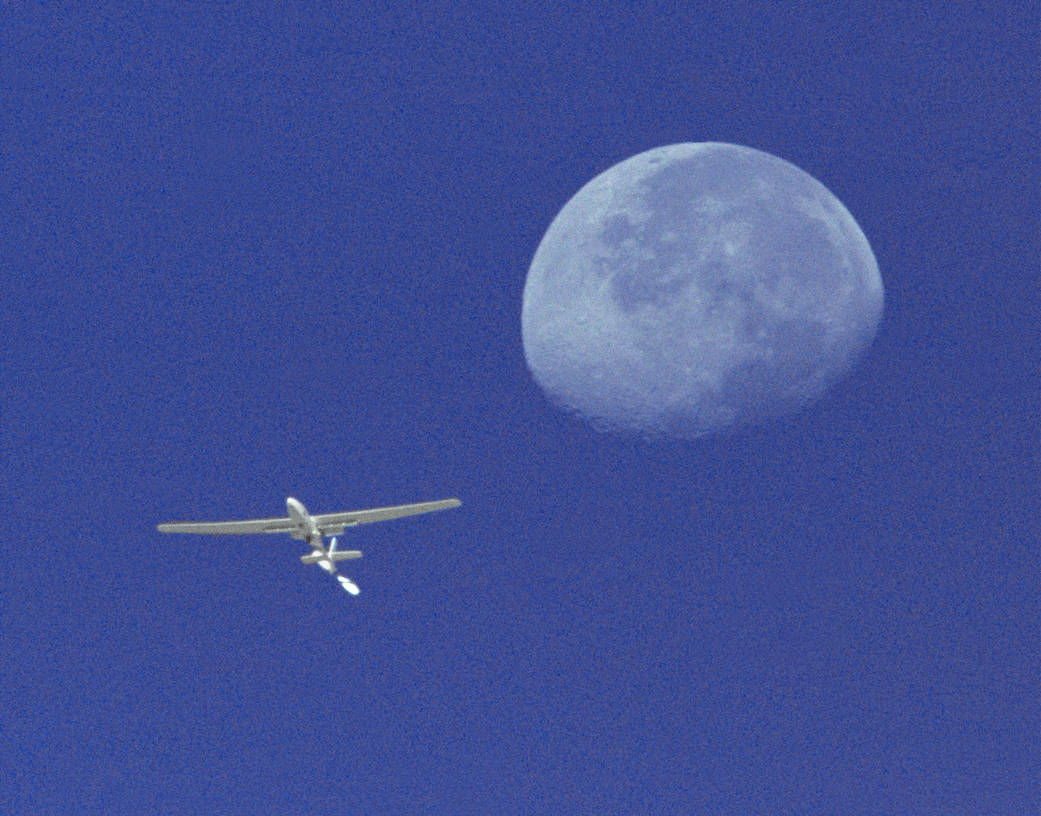 The Perseus A, a remotely-piloted, high-altitude research aircraft, is seen here framed against the moon and sky.