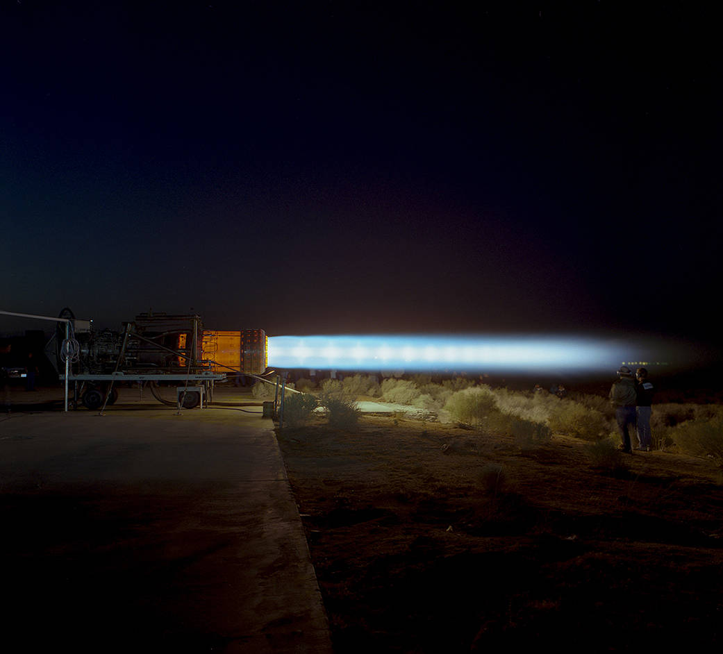 A J58 turbojet engine, anchored to the ground, is in full afterburner and parts of the engine are glowing.