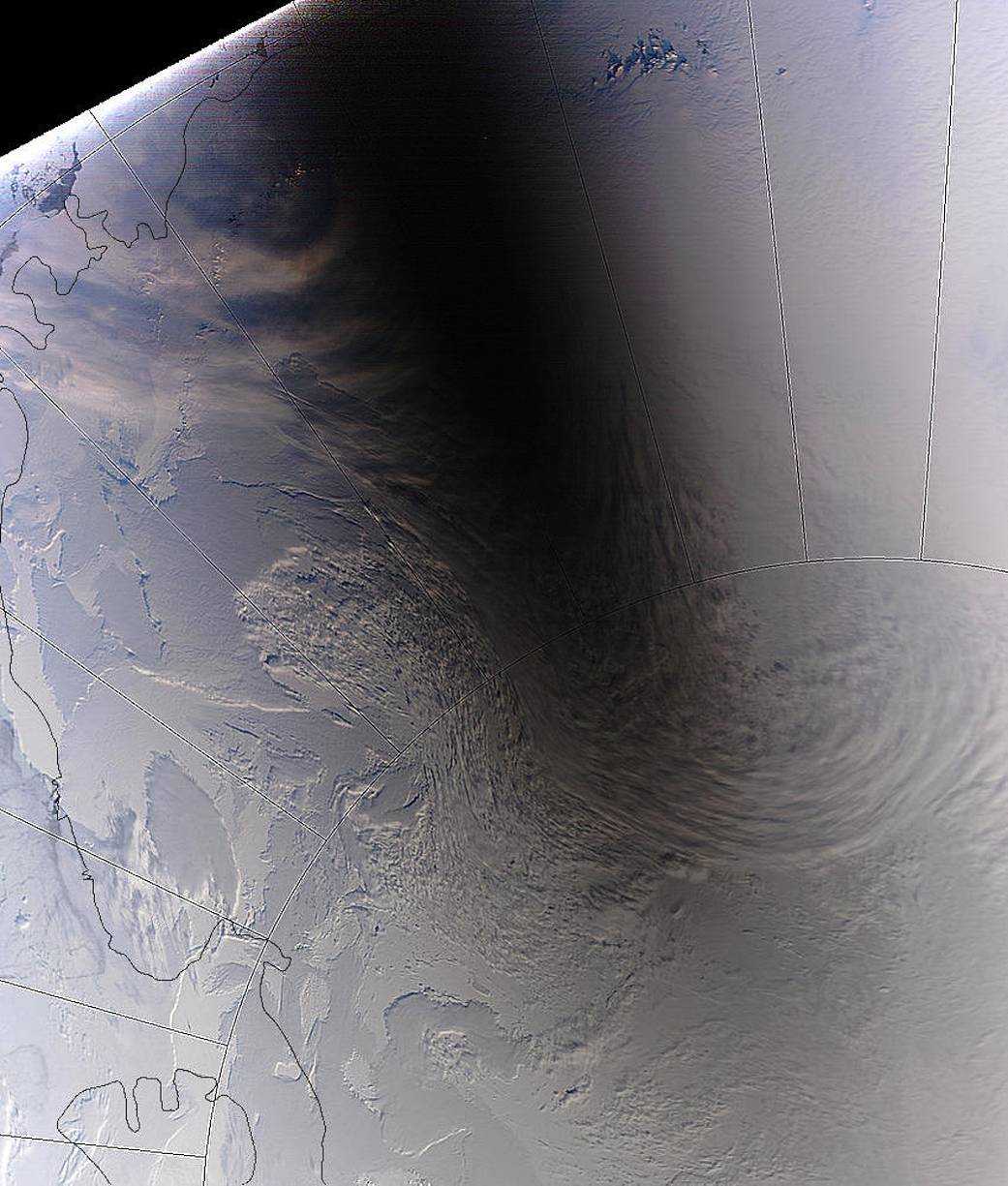 Total solar eclipse photographed by satellite showing long shadow across snow covered land