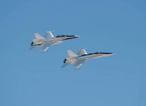 Two F/A-18 aircraft flying in tight formation.