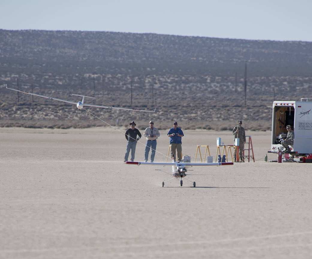 With a 1/3-scale sailplane behind it already in the air, the DROID-3 tow plane rotates for takeoff from the dry lakebed, both co