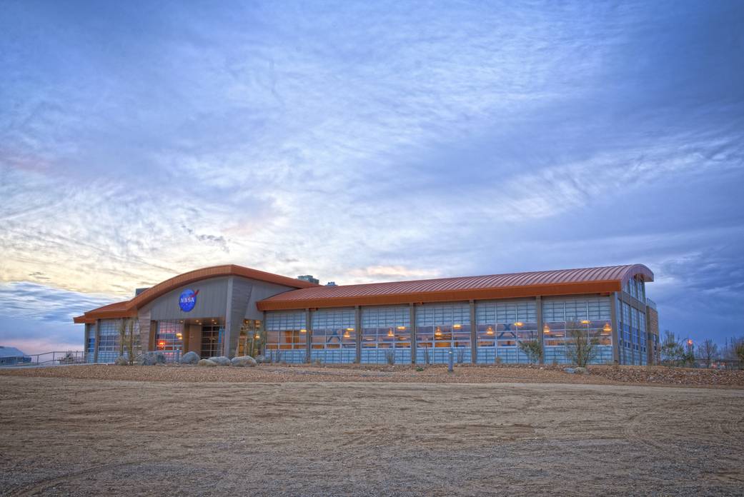 Late afternoon clouds and interior LED lighting highlight the front of the new Facilities Support Center at NASA's Dryden Flight