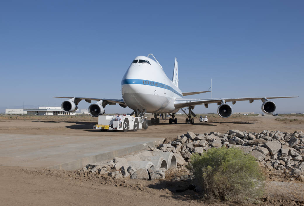 Retired NASA space shuttle carrier aircraft No. 911 is towed across a bridge over a drainage culvert on the final leg of its sho