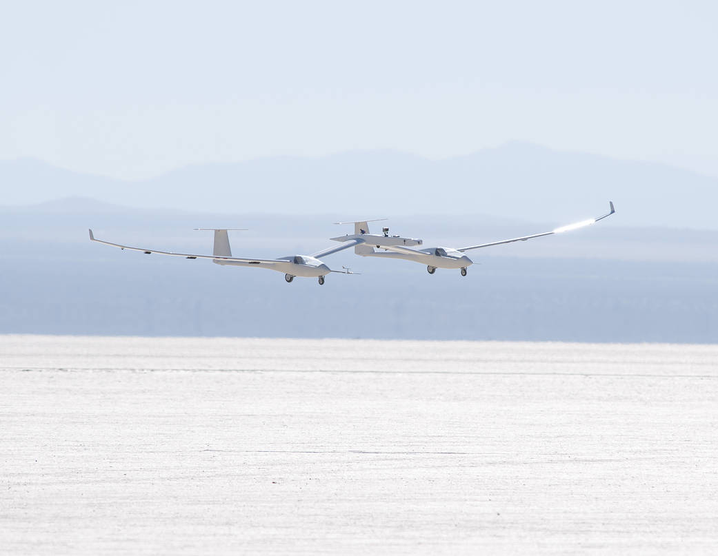 The one-third scale twin-fuselage towed glider glides in for landing on Rogers Dry Lake.