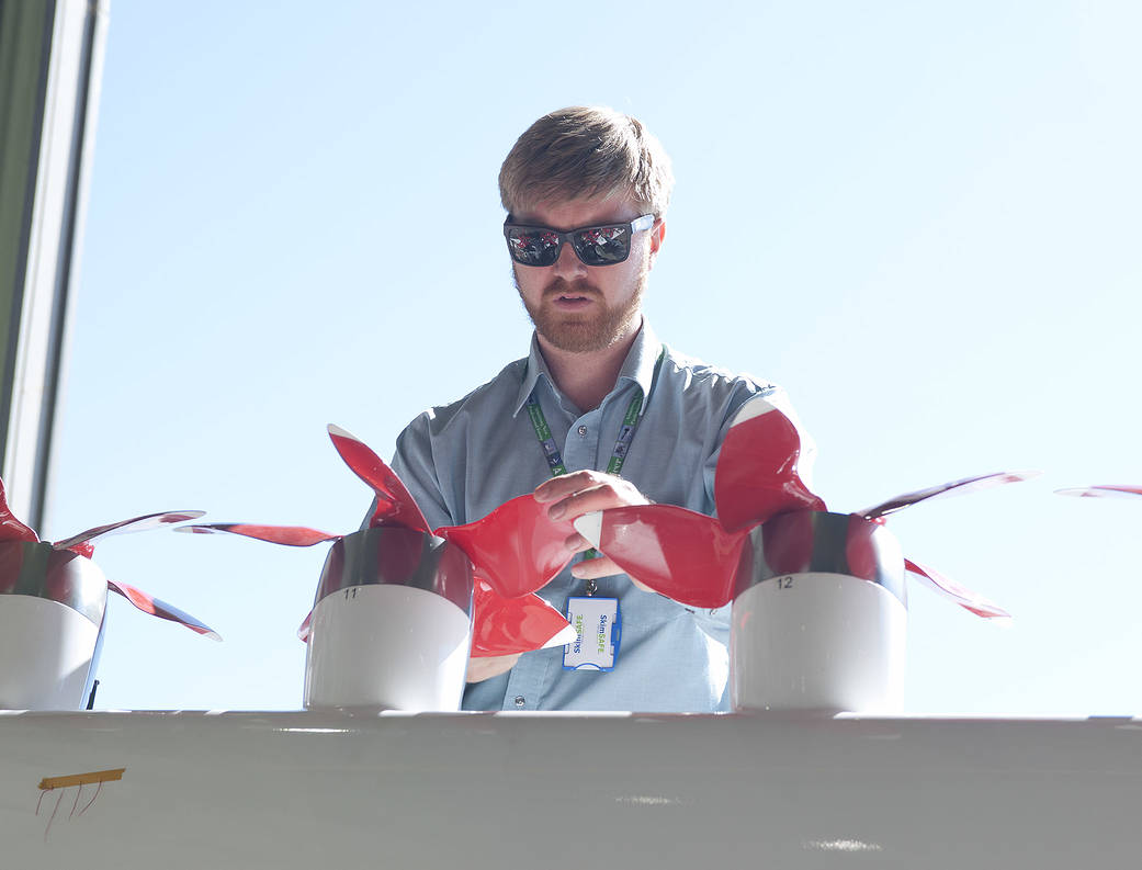 An engineer inspects a propeller on a modified wing for the Hybrid-Electric Integrated Systems Testbed.