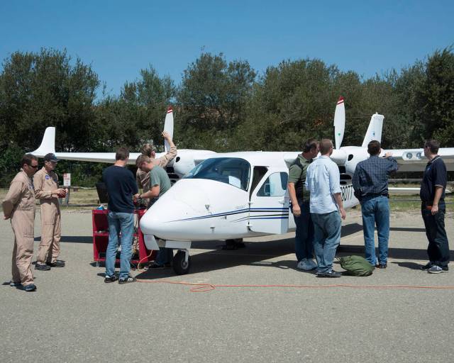 Pilots and engineers from NASA’s Armstrong Flight Research Center inspect a Tecnam P2006T