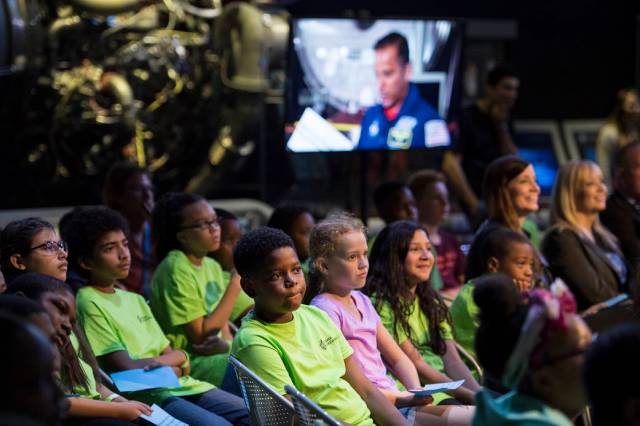 A group of students watching an in-flight downlink.
