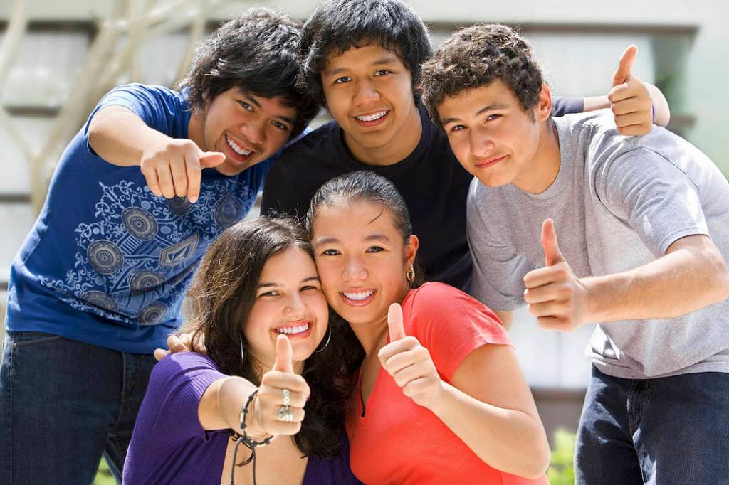 Group of teenagers with thumbs up.