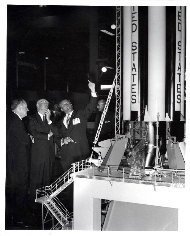 Dr. Wernher von Braun (right) briefs President Dwight D. Eisenhower (center) on a model of the Saturn I vehicle at Marshall.