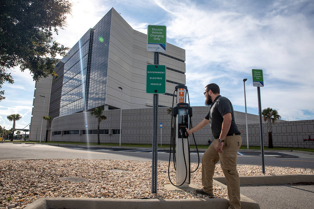 Spencer Davis, transportation specialist at Kennedy Space Center in Florida, checks out one of the new electric vehicle charging stations near the headquarters building.