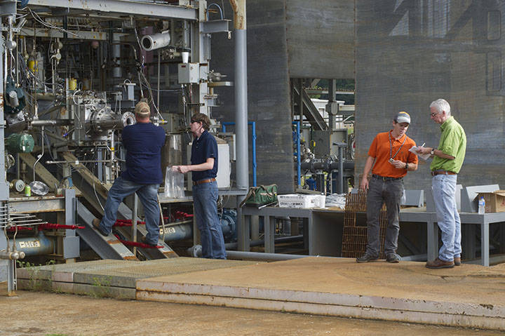 Lead test engineer Ryan Wall, right orange shirt, prepares to hot-fire test a 3-D printed rocket part on Test Stand 115.