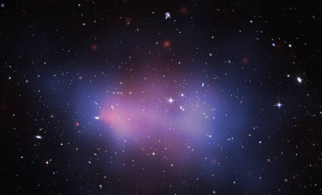 A cloud in a Chandra image features a field of distant galaxies and stars with a bright blue, cone-shaped cloud at its core. The cloud is superheated gas in the galaxy cluster known as u0022El Gordou0022, meaning u0022Fat Oneu0022 in Spanish.