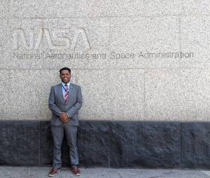 Scientist Emil Cherrington standing in front of the original NASA logotype, also known as the "worm."