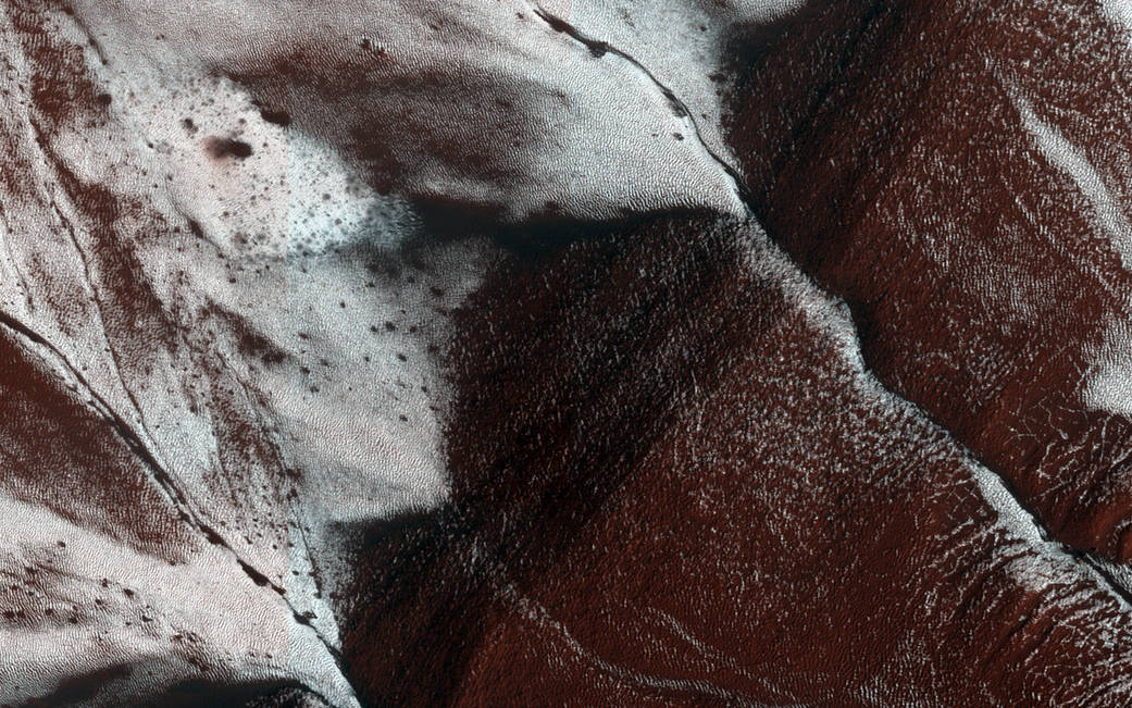 Image of frosted gullies on a south-facing slope within a crater on Mars, approximately 1.5 by 3 kilometers in area. 