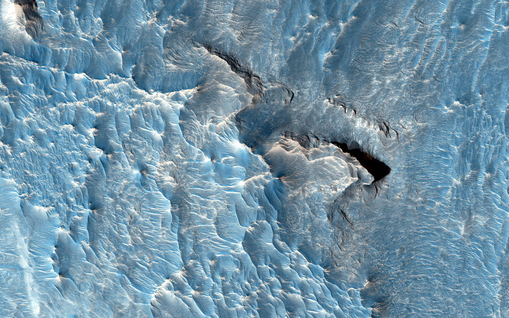 Light toned deposit with shadow on rough terrain