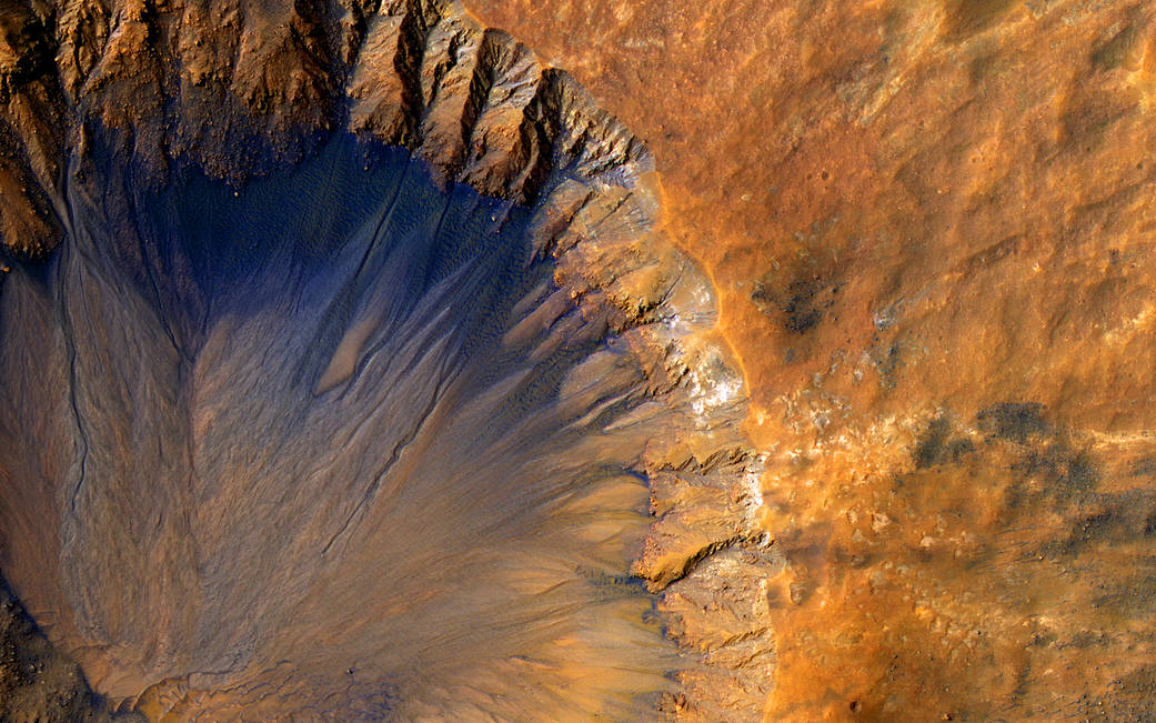 Closeup of Mars crater showing a quarter of the crater at left and surface at right