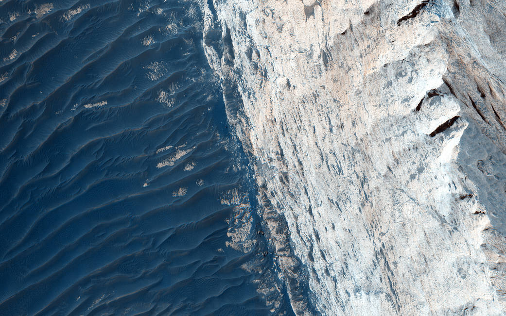 Sedimentary layers on Mars surface in blue tones on left half of image and white on right