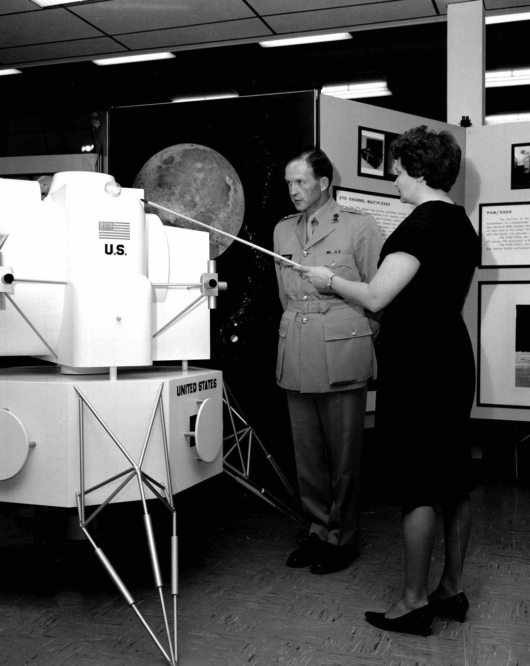 Evelyn Falkowski and British Colonel John Stevenson discussing space hardware exhibit at the Space Orientation Center.