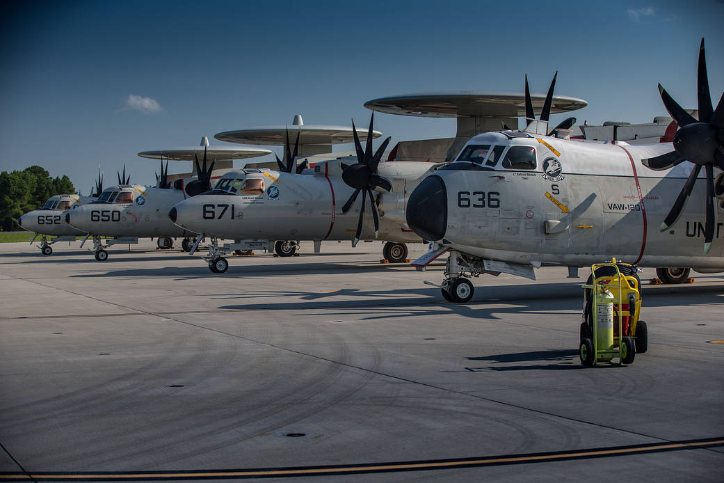 Multiple E-2 planes lined up on a runway.