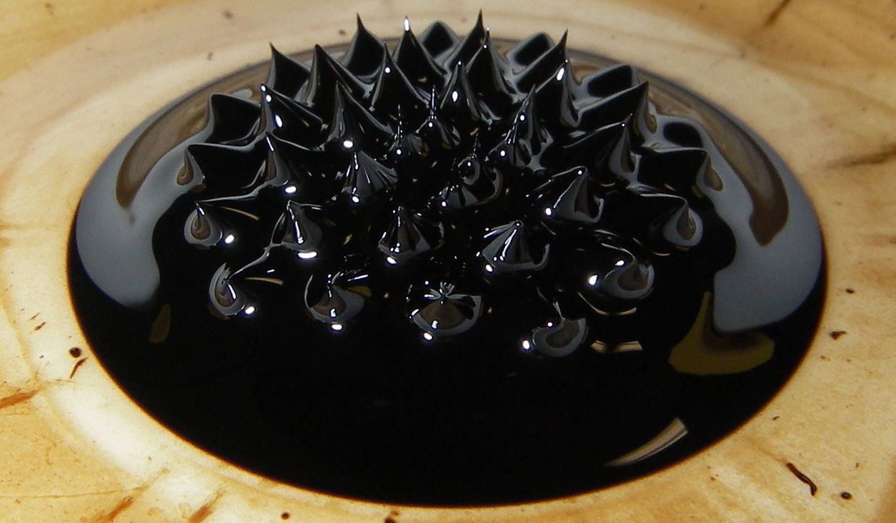 Pool of dark fluid being manipulated by magnetic field.