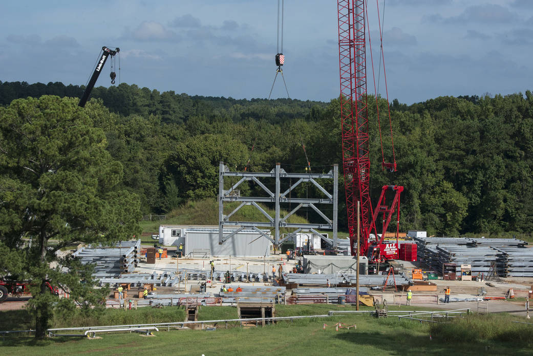 A crane positions the first steel piece for twin towers of a 215-foot-tall structural test stand for NASA's Space Launch System.