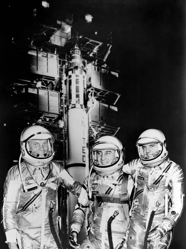 Freedom 7 crew of John Glen, Gus Grissom, and Alan Shepard in their space suits in front of the Redstone rocket.