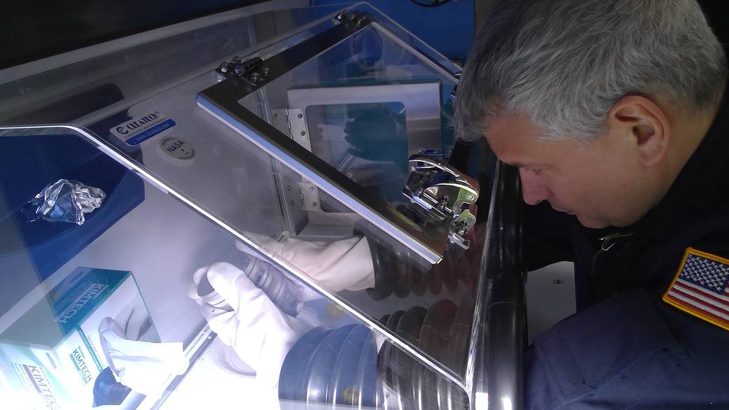 HERA crew member Patrick Ridgley handles rock samples stored within a glovebox during a simulated journey to the Martian moon Phobos. 