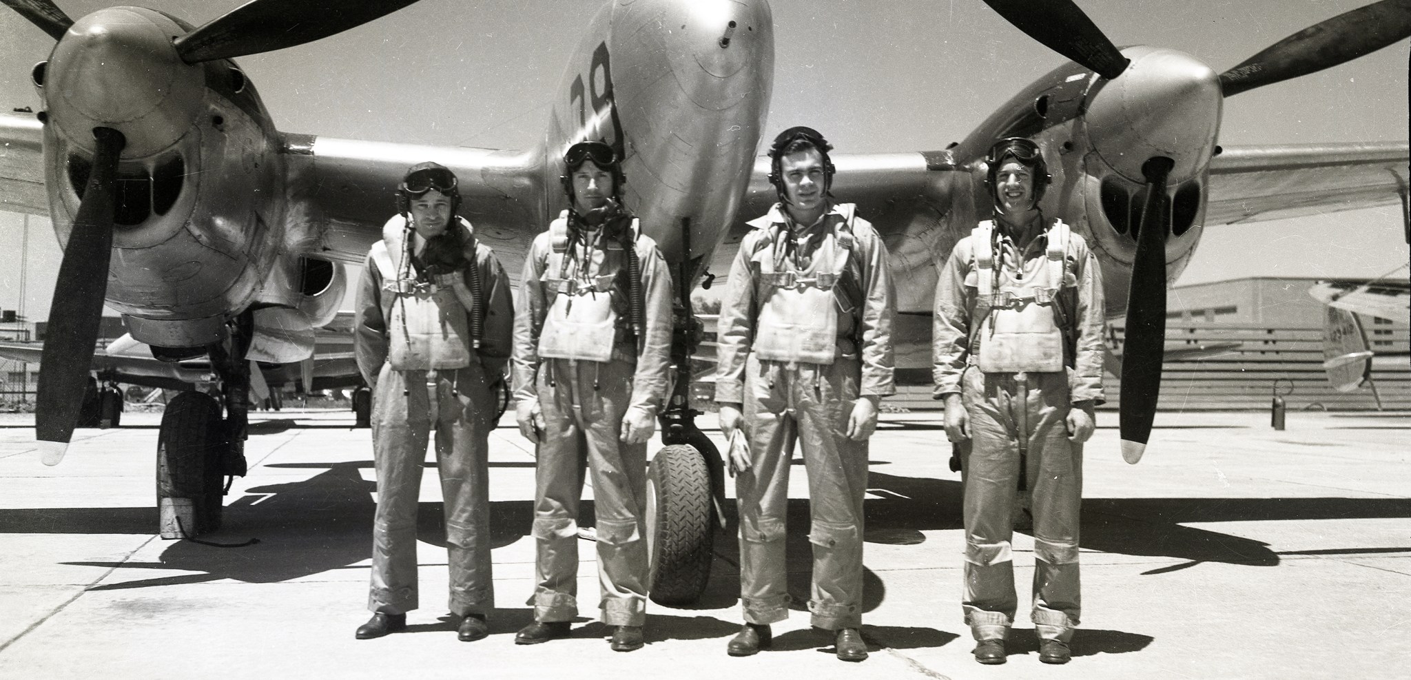 Four pilots standing in front of aircraft.
