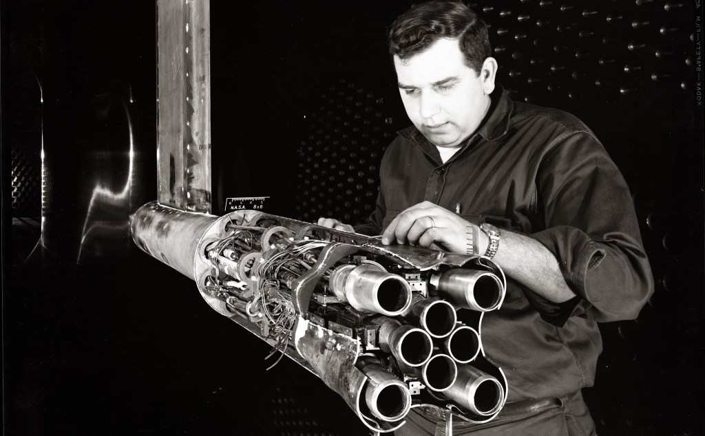 Man with rocket model in wind tunnel.