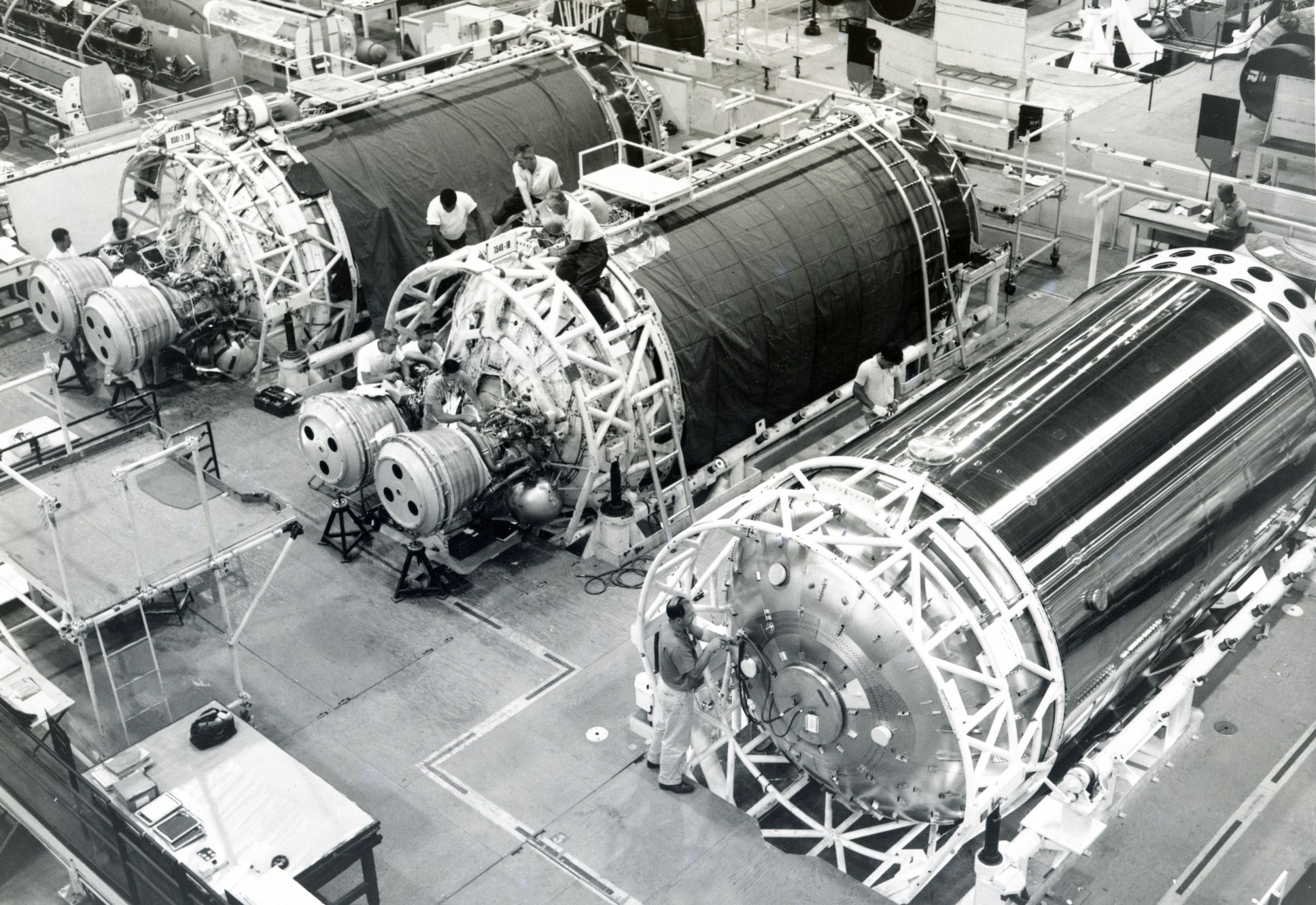 Three rocket stages lying on side in factory.