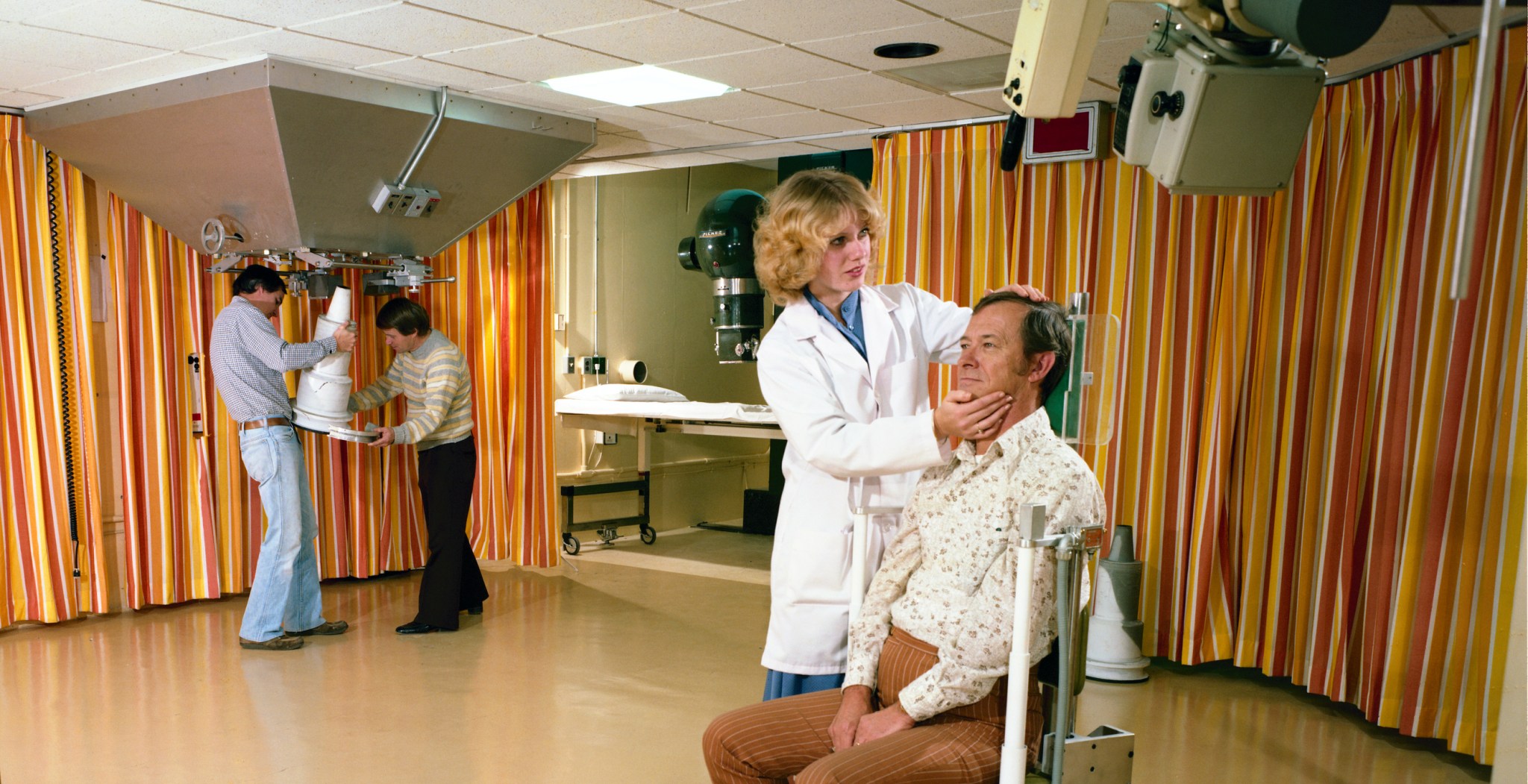 Nurse examines man in chair.