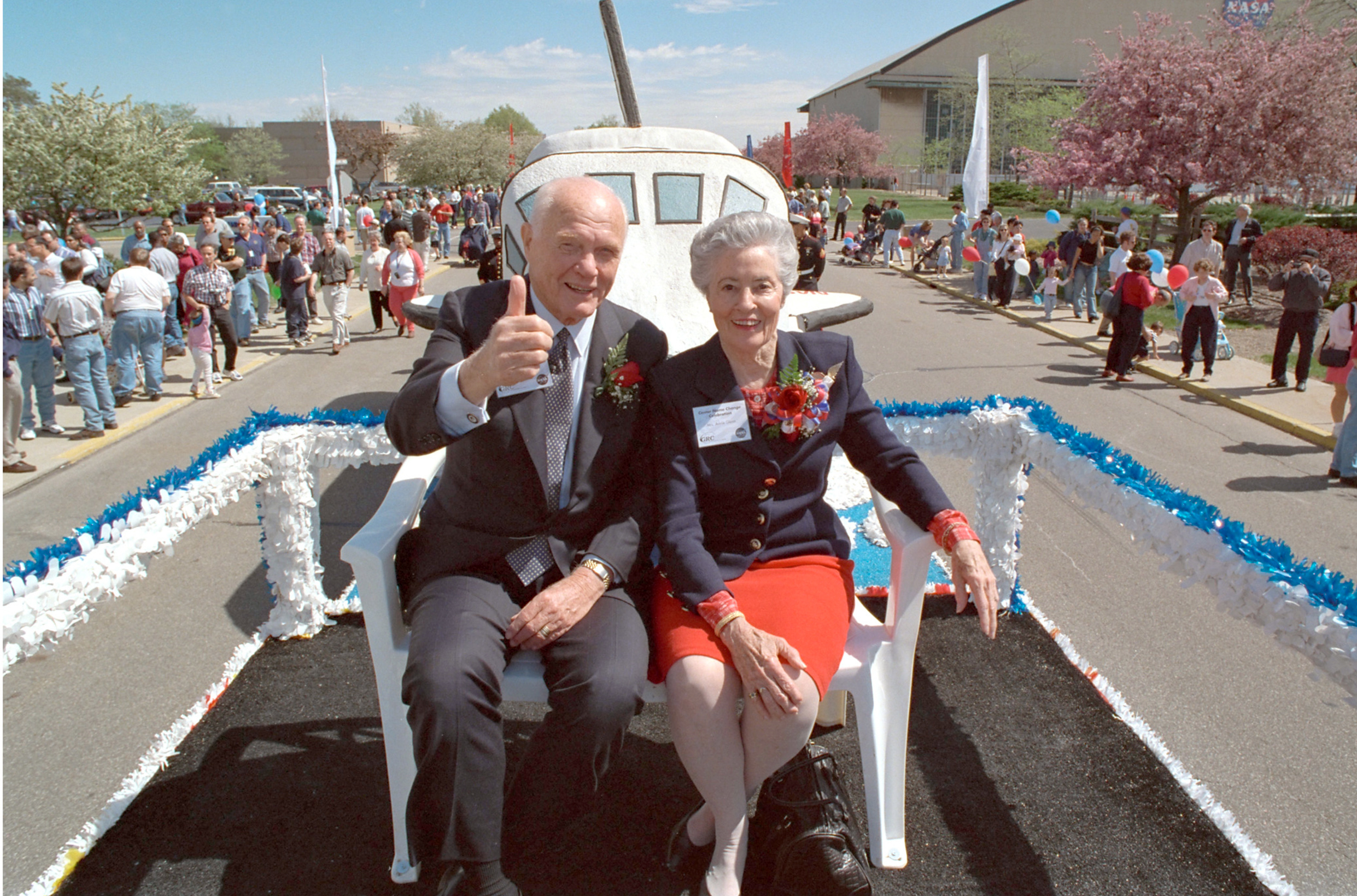 John and Annie Glenn smiling on parade float.