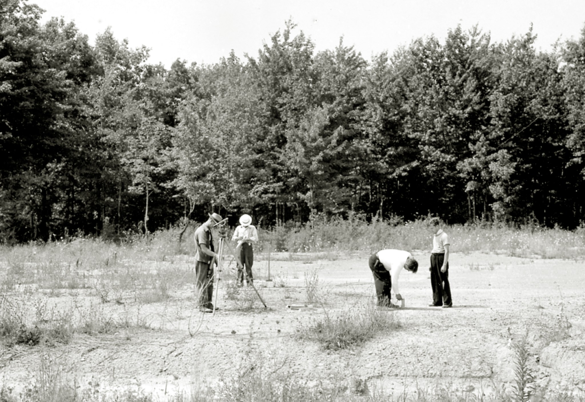 Men in field with surveying equipment