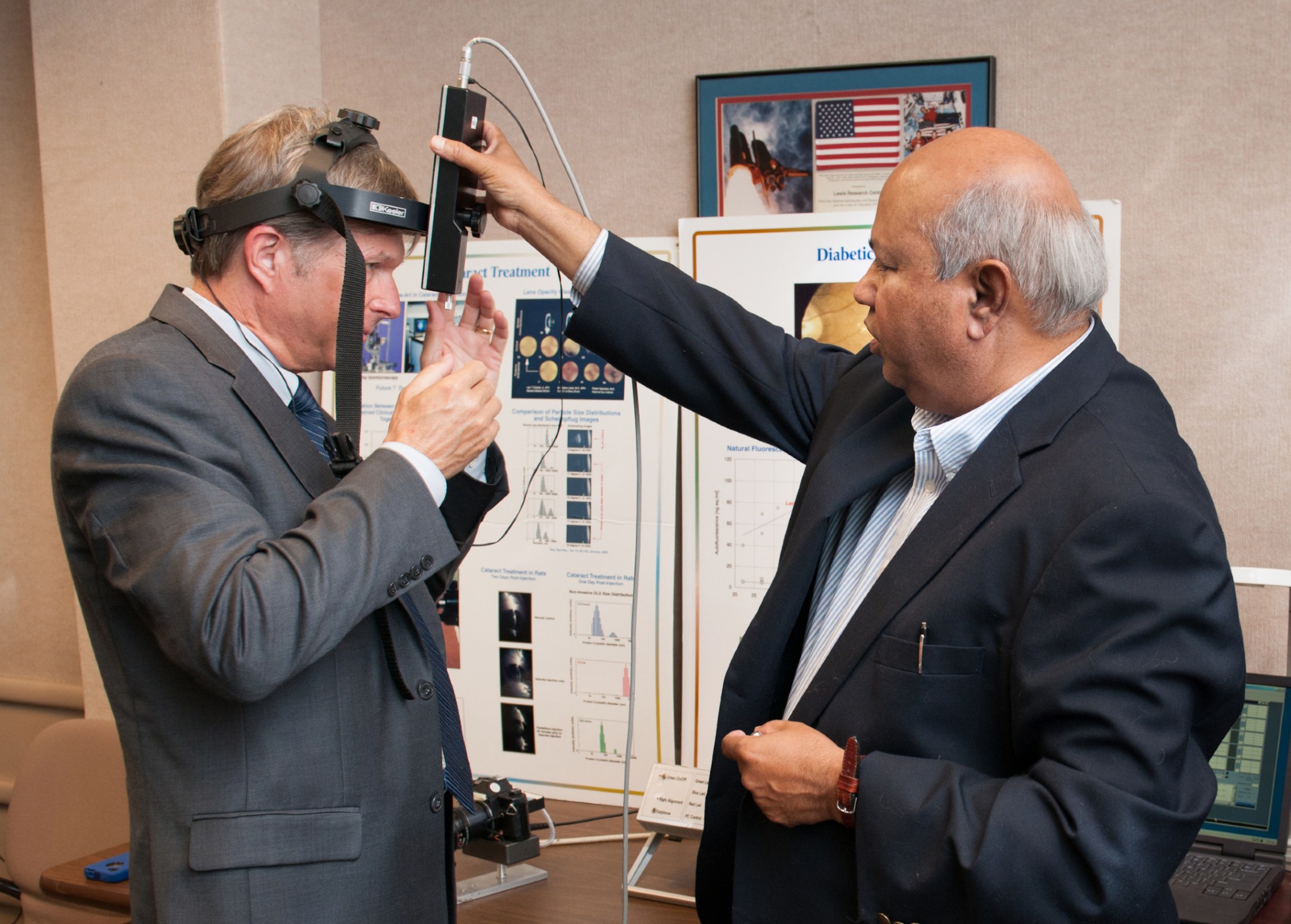 Man adjusts measurement equipment on the head of another man.