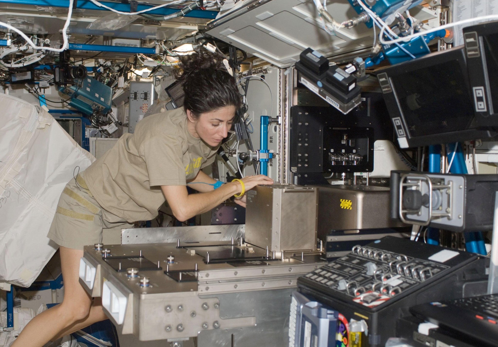 Woman working on equipment in space station.