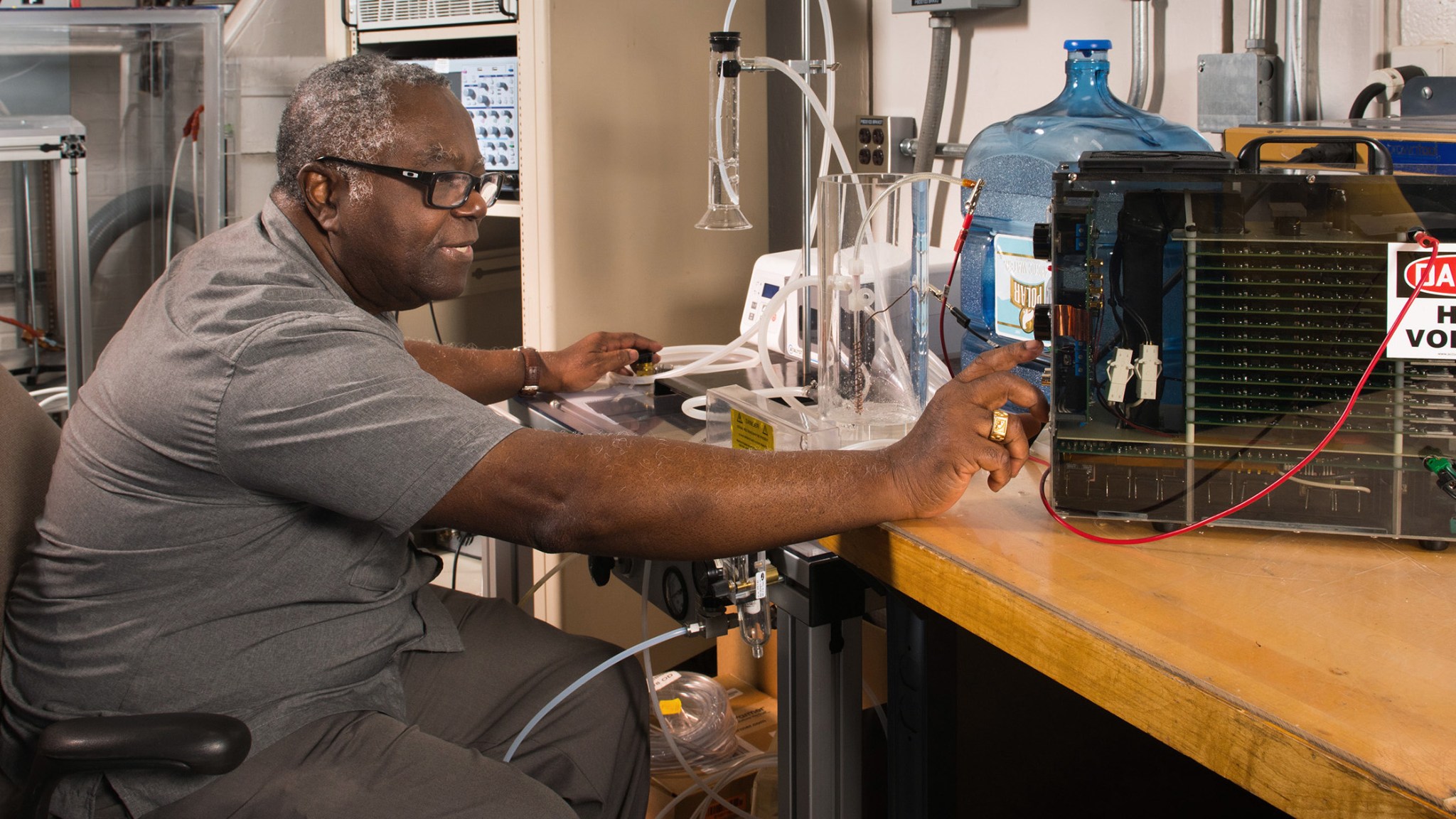 Man works with water purification equipment on desk.