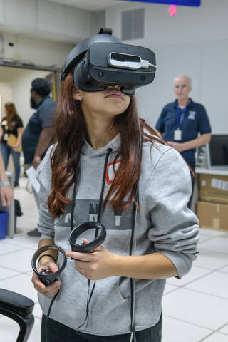 Female student wearing VR goggles looking at an angle toward the camera.