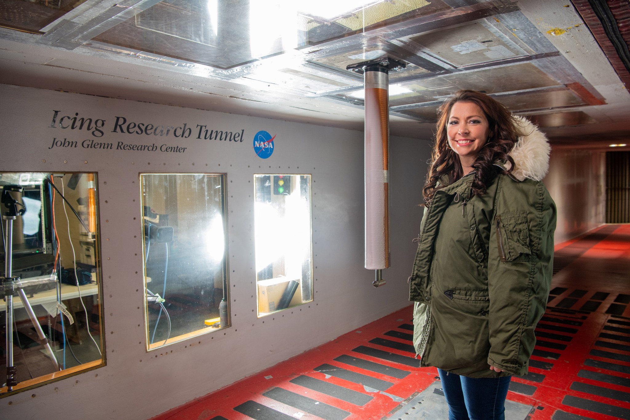 Smiling female researcher wearing a parka poses inside the icing research tunnel at Glenn Research Center