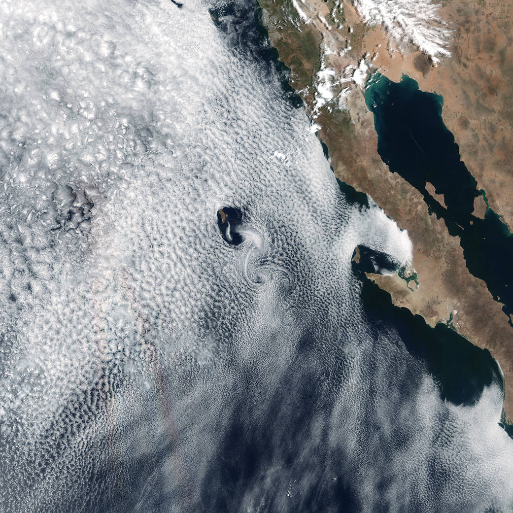 Satellite image of cloud swirls over islands