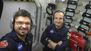 HERA crew members Dragos Michael Popescu and Pietro Di Tillio wear headsets to coordinate with others on a simulated Mars mission with communication delays. 