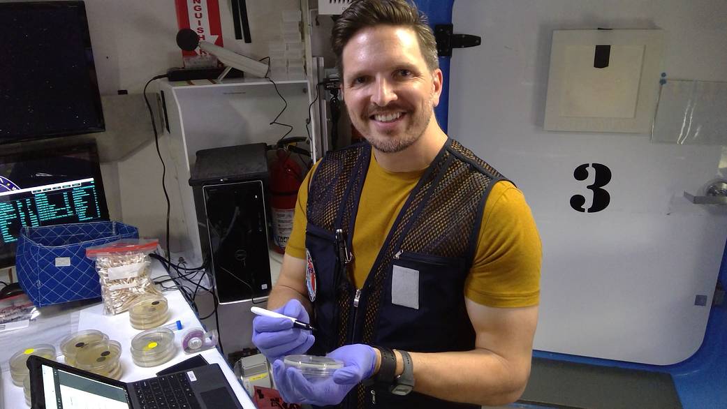HERA crew member Christopher Roberts holds a petri dish for storing swabs of microbes from the habitat.