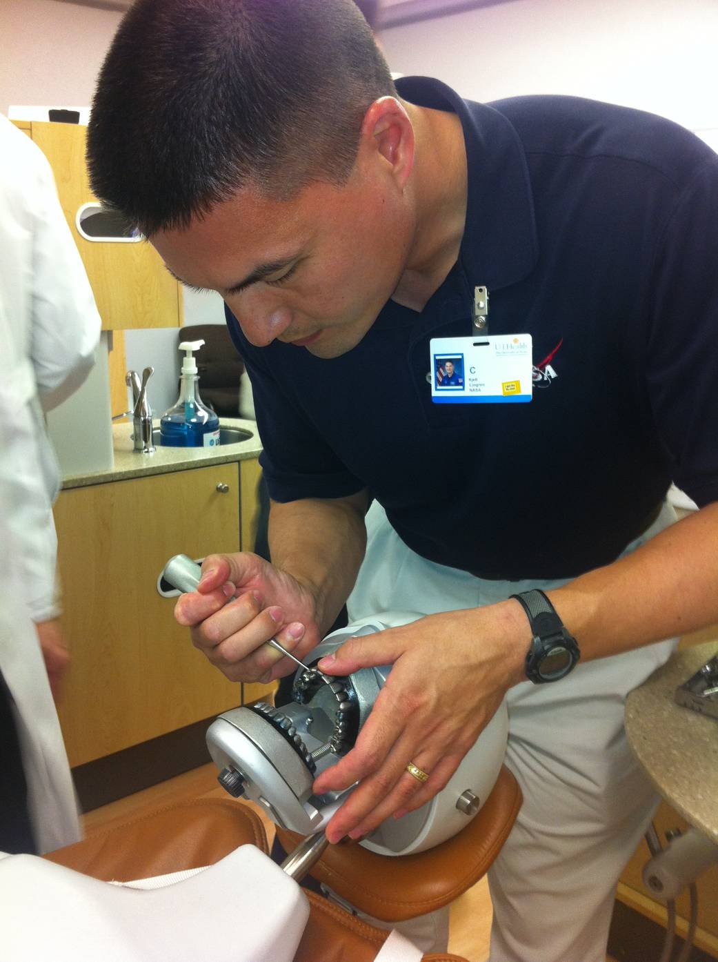 An astronaut practices tooth extraction on a model.