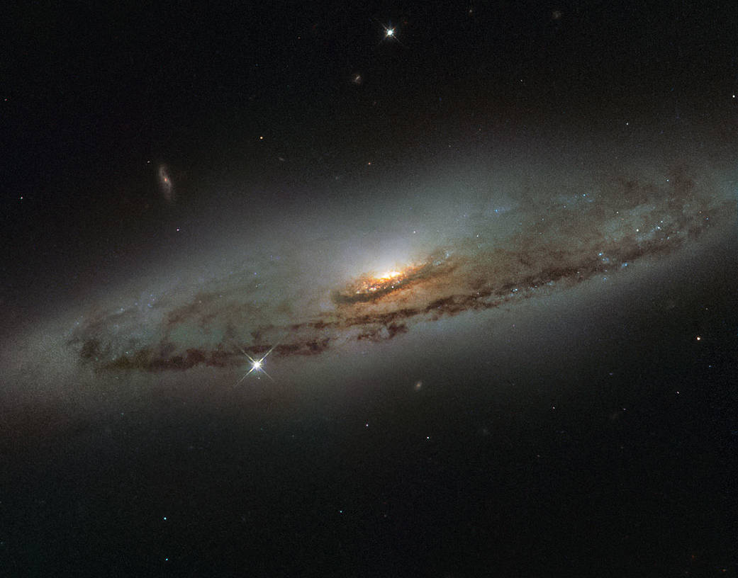 Image of spiral galaxy NGC 4845, a flat and dust-mottled disk surrounding a bright galactic bulge.