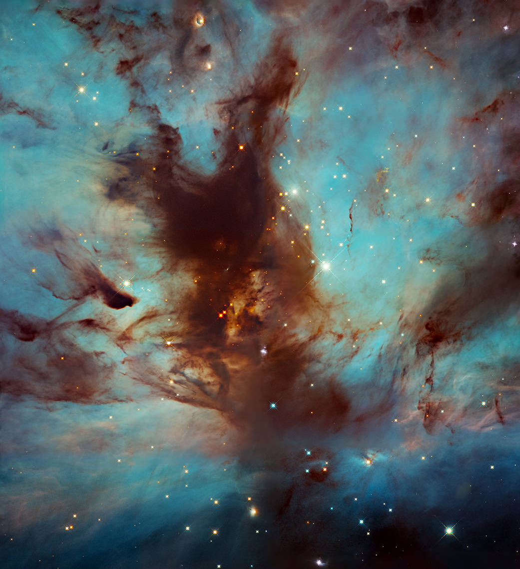 dark nebula looking like a flame rising through the center of the image against a turquoise and blue glowing nebula, stars dotted throughout