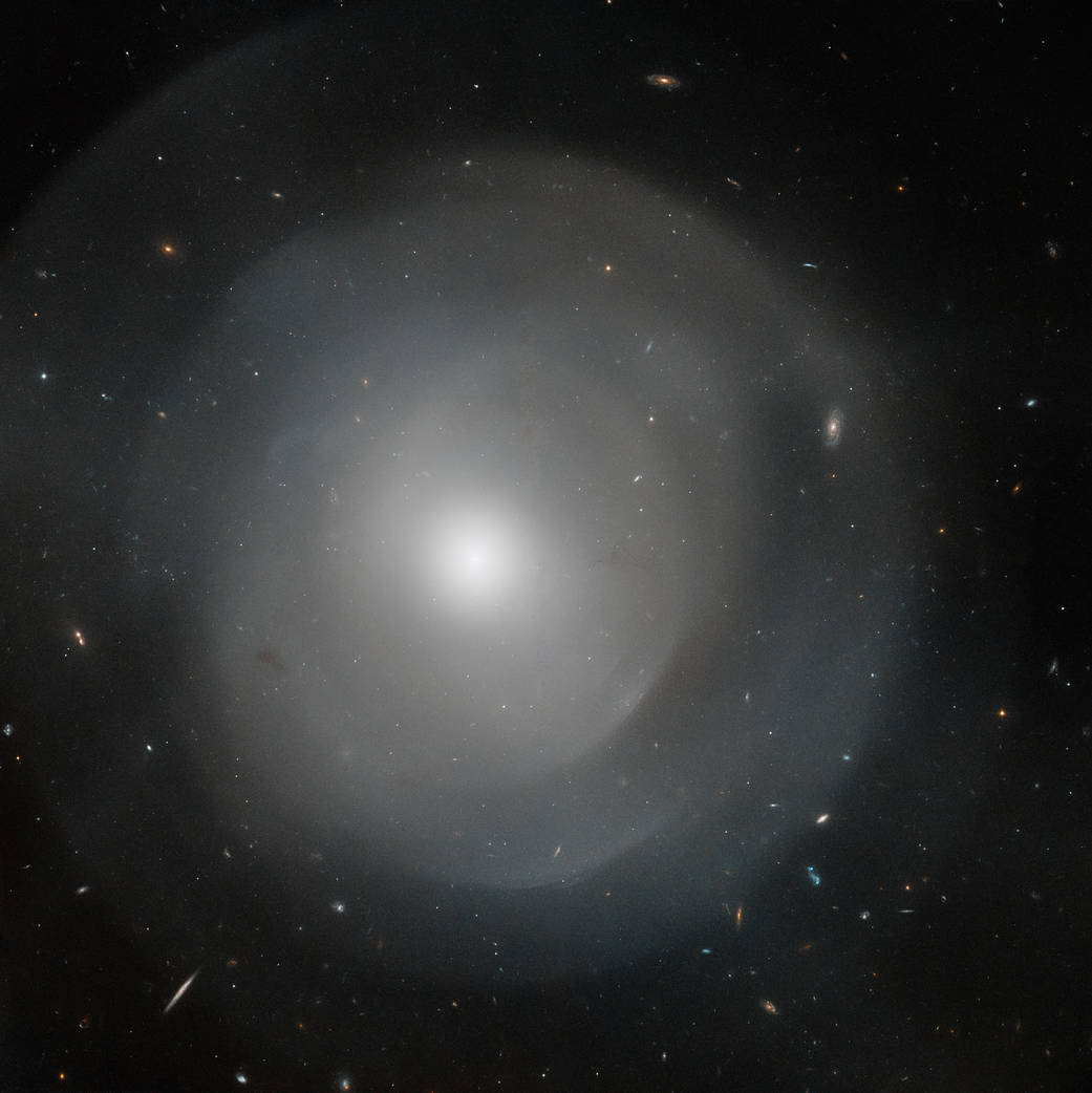 Bright, white diffuse sphere with an extremely bright core. Diffuse shells of matter form layers around the core