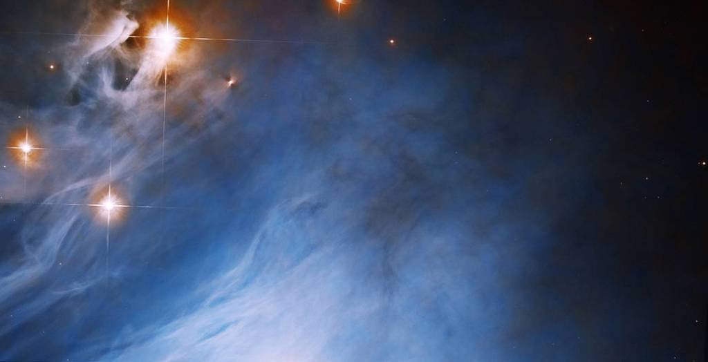 research white dwarf star bright blue cloud fills the scene, orange-red rings surround bright-white stars in the upper-left corner of the image
