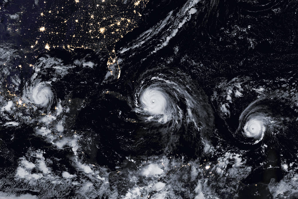 Nighttime satellite image of Atlantic ocean with three hurricanes