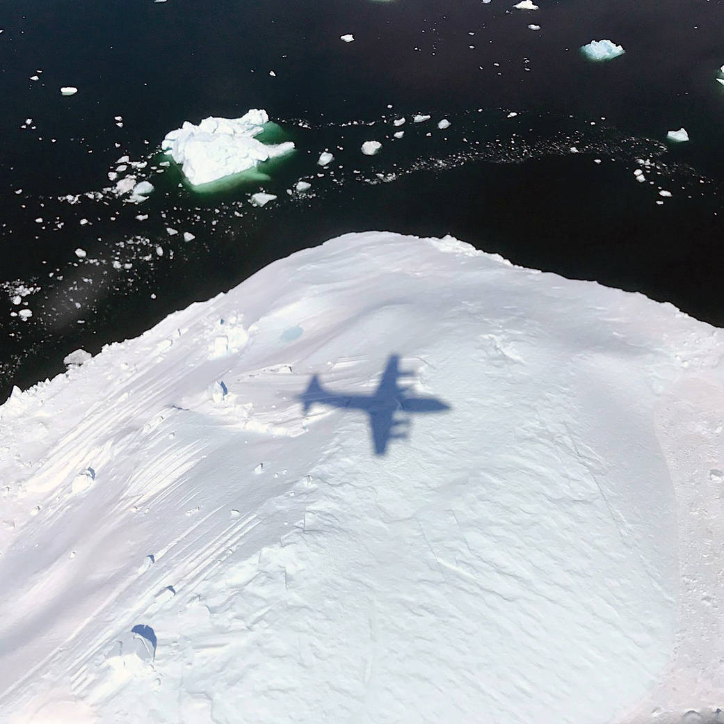 shadow of aircraft from above flying over iceberg